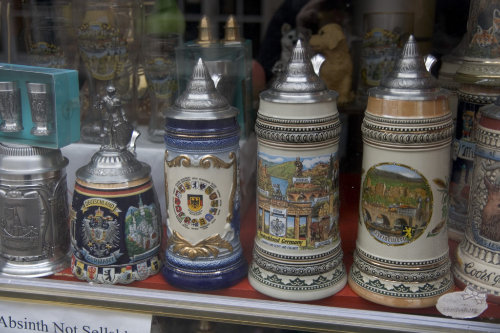 Several ornate German beer steins on display behind glass